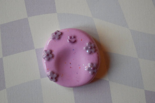 Pink happy face worry stone, handmade clay fidget stone with glitter finish, top view