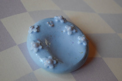 Blue happy face worry stone showing thumb indent, pocket-sized stress relief stone